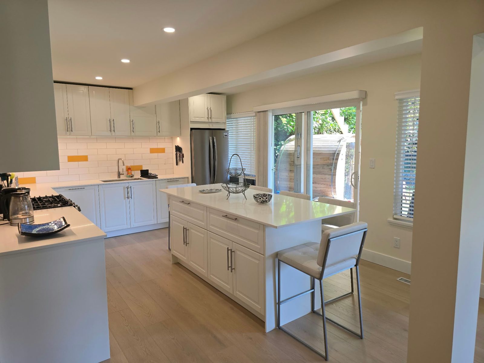 Kitchen with an island and a sliding glass door to the garden.