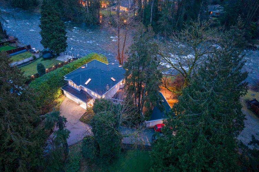 Aerial view of the property and driveway among tall firs