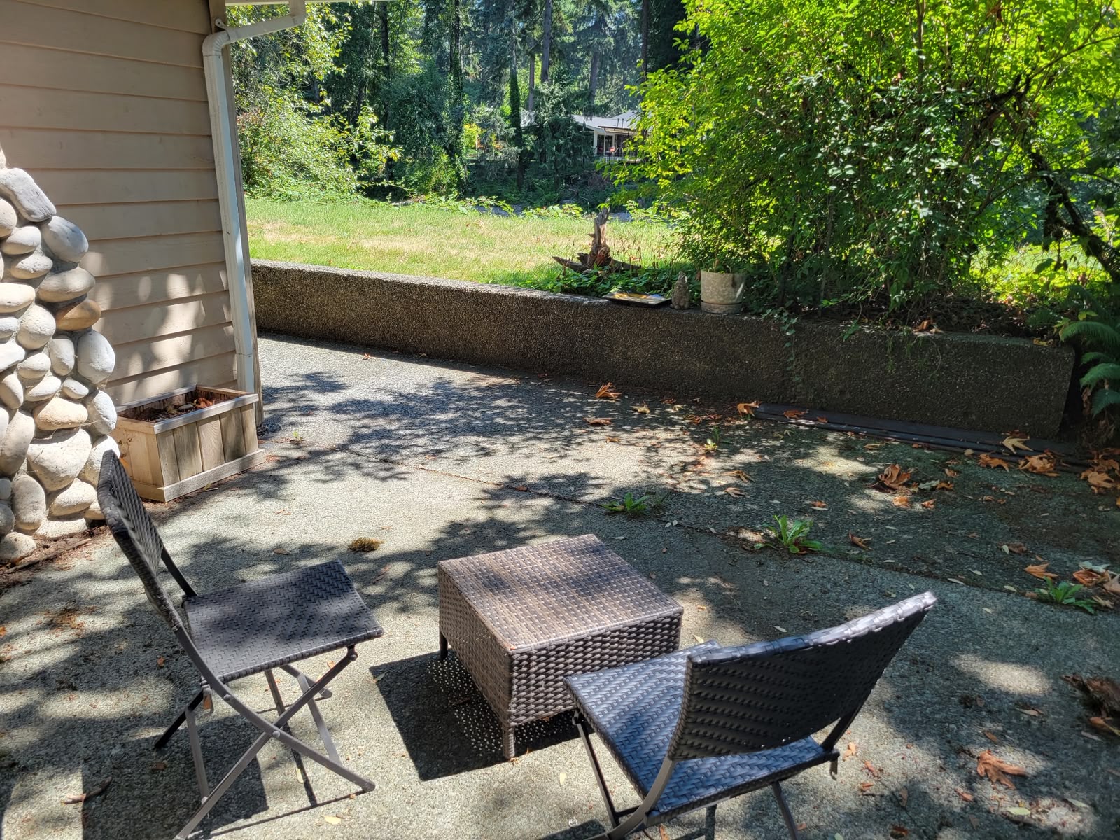 Private patio with seating looking out over the lawn and trees